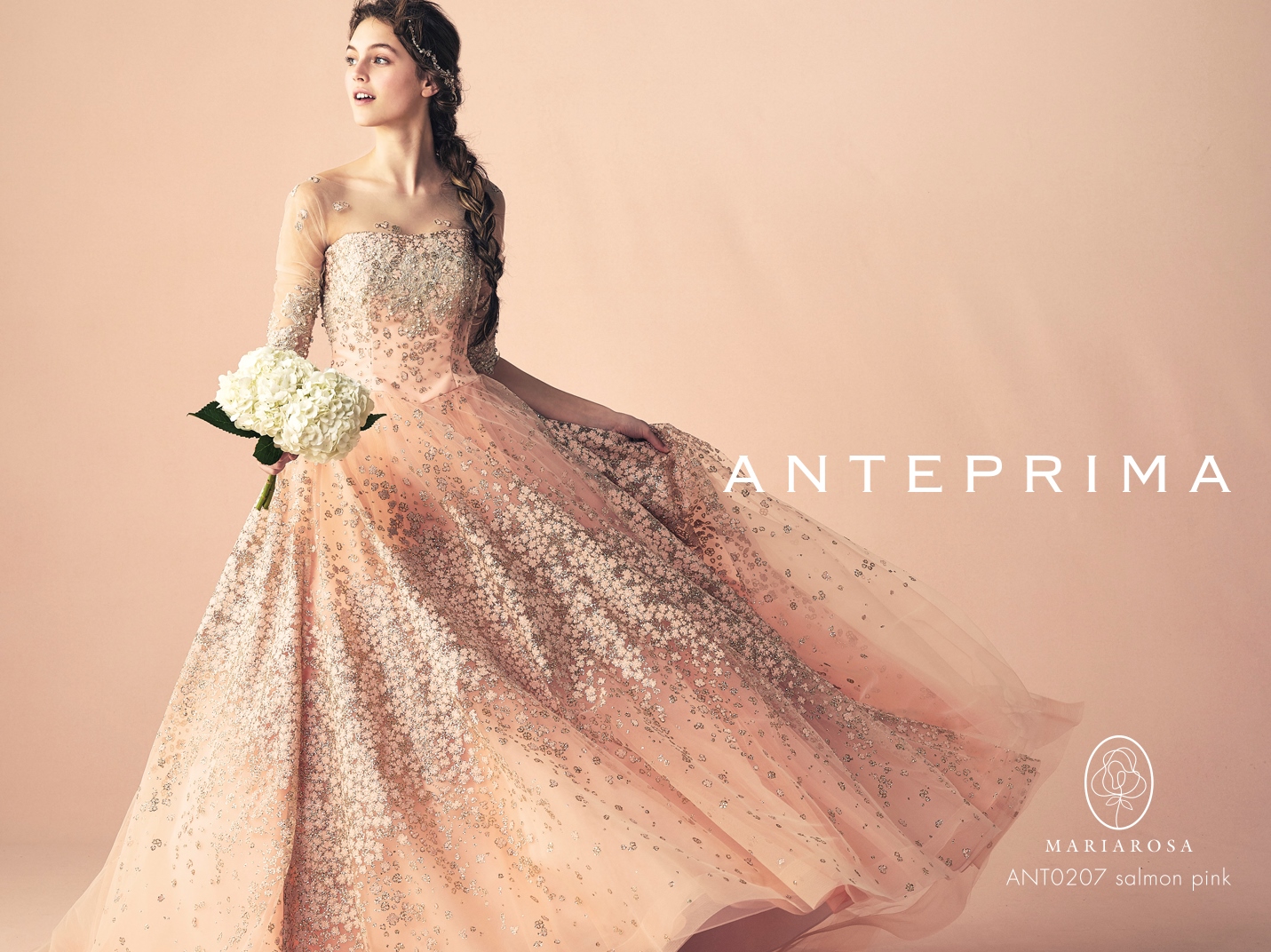 ANTEPRIMA（アンテプリマ）サーモンピンクとゴールドチュール。スタイルにとらわれず不動の華やかさを追求し続けるANTEPRIMA。立体感の小花が咲きほこる2辺グリッターが すべての花嫁さまが納得のエレガントさを演出します。人気の素材を美しいシルエットで作り上げた一着は高級感溢れます。